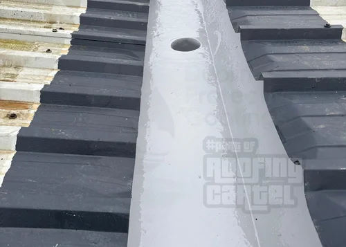 Completed liquid rubber coating on metal roof valley showing seamless finish